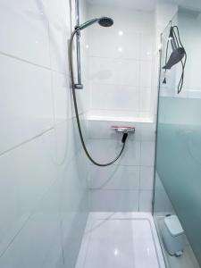 a white bathroom with a shower and a toilet at Ferienwohnung Nelia in Lübeck
