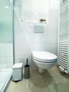 biała łazienka z toaletą i prysznicem w obiekcie Ferienwohnung Nelia w Lubece