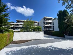 an apartment building with a white wall and trees at Ferienwohnung Nelia in Lübeck