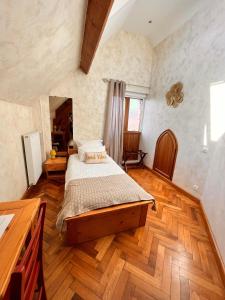 um quarto com uma cama e piso em madeira em La ferme du paradis em Merris