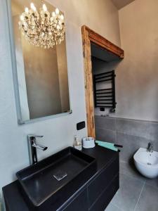 baño con lavabo negro y espejo en Curt da Beta - suggestivo appartamento in Corte del '700, en Malnate