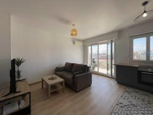 a living room with a couch and a table at California Park - Wifi, AC, 4 pers in Nice