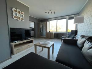 a living room with a couch and a flat screen tv at RONY apartment in Liepāja