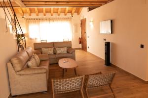 ein Wohnzimmer mit einem Sofa und einem Tisch in der Unterkunft Casas Las Hazas in La Cuesta