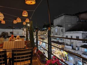 two people sitting at a table on a balcony at night at The Boutique Hotel Amman in Amman