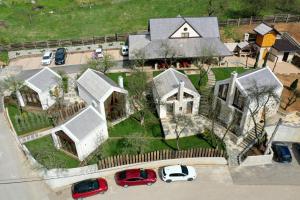 una vista aérea de una casa con coches estacionados en un estacionamiento en Toplik Village Resort en Uzdojnice