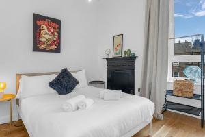 - une chambre avec un lit blanc et des serviettes dans l'établissement spacious flat, close to the city centre with scenic views, à Édimbourg