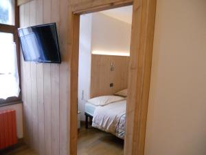 ein kleines Zimmer mit einem Bett und einem TV. in der Unterkunft Casa Alberti in Valfurva