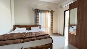 a bedroom with a large bed and a window at Goshen Inn in Bangalore