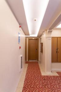 um corredor com um quarto com tapete vermelho em LARA HOTEL em Istambul