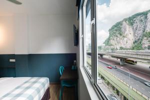 a bedroom with a window with a view of a highway at The Concept Hotel KL - Batu Caves in Batu Caves