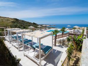 a view of a beach with chairs and umbrellas at Spiros-Soula Thematic Suites in Agia Pelagia