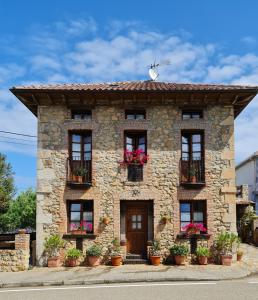 a stone building with potted plants on it at La Torruca in Oreña