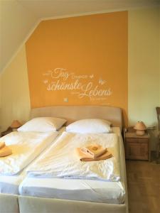 2 camas en un dormitorio con un cartel en la pared en Waldgasthof Röckers-Ferienwohnung Hahnenkrai, en Meppen