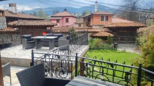 a patio with a table and chairs in a yard at Guest House Zlatniyat Telets in Koprivshtitsa