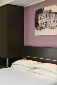 1 dormitorio con 1 cama y una foto de una casa en Hotel Vienna, en Lido di Jesolo