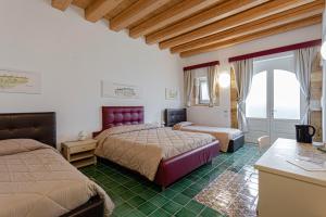 锡拉库扎Hotel Casale Milocca的一间卧室，有两张床、一张书桌和一扇窗户 更多37张照片