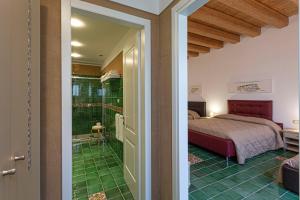 锡拉库扎Hotel Casale Milocca的一间卧室设有一张床,并铺有绿色地板。