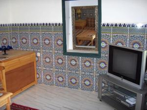 Villa Romancia Ourika Vallee في مراكش: غرفة معيشة مع تلفزيون ومرآة