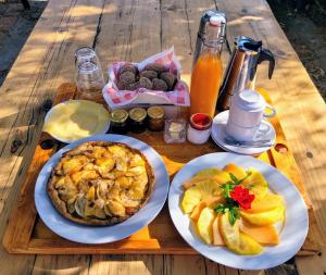 einen Tisch mit Teller mit Lebensmitteln und Obst in der Unterkunft Stazzu la Capretta Farm Camping & Guest Rooms in Olbia