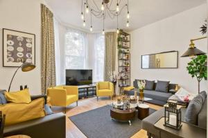 - un salon avec un canapé, une table et des chaises jaunes dans l'établissement Charming Apartment Earls Court, à Londres