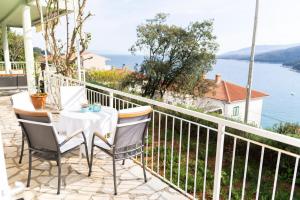 een tafel en stoelen op een balkon met uitzicht op het water bij Porto Albona in Rabac