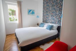 a bedroom with a large bed with blue pillows at Porto Albona in Rabac