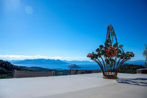 The Boatyard Luxury Villa في Tzíkidhes: مزهرية من الزهور تقف على طاولة