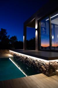 a house with a swimming pool at night at The Boatyard Luxury Villa in Tzíkidhes