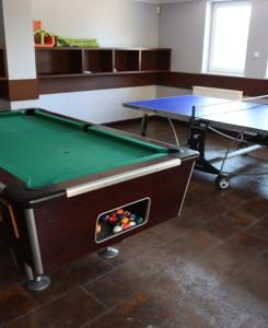 a pool table in a room with two tables at Karla, apartamenty i pokoje w Dębkach in Dębki