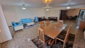 uma sala de estar com uma mesa de madeira e cadeiras em Sea View Heart Apartment (families only) em Alexandria