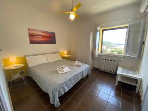 a small bedroom with a bed and a window at Alabe Hotel in Tresnuraghes