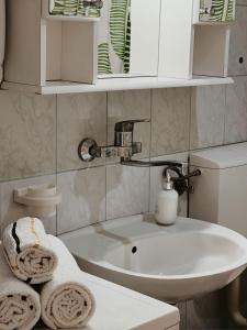 a bathroom with a white sink and towels at Holiday Home Old Town in Sarajevo