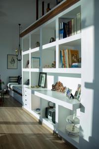 a room with a white book shelf with books at The Boatyard Luxury Villa in Tzíkidhes