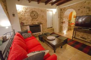 ディミツァナにあるVilla Malevi Dimitsanaの赤いソファとテレビのあるリビングルーム