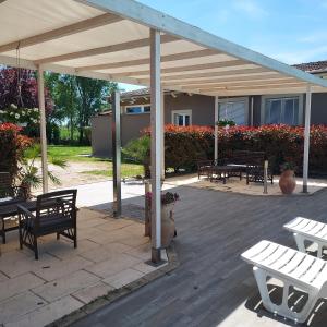 a patio with benches and tables and a pavilion at Ca Giuliocesare in Castiglione di Ravenna