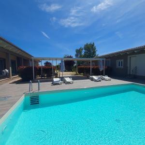 a large swimming pool with chairs and a house at Ca Giuliocesare in Castiglione di Ravenna