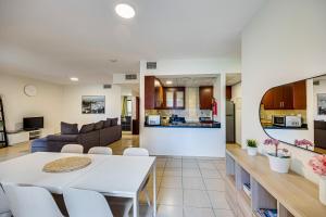 Big Apartment in Murjan, JBR, near the beach في دبي: مطبخ وغرفة معيشة مع طاولة وكراسي بيضاء