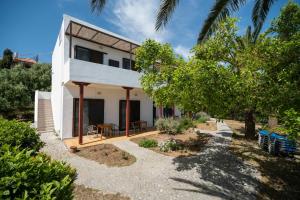 Casa blanca con patio y árboles en Milos studios & Beach House, en Frangokastello