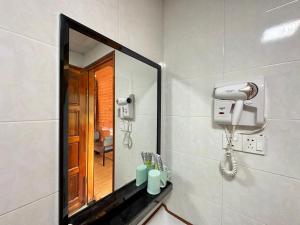 a bathroom with a mirror and a hair dryer at Shunde Palm Resort 仙本那顺德人家棕榈园 in Semporna