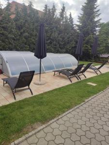 a group of chairs and umbrellas on a patio at Jankó Apartman in Siófok