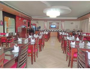 a dining room with tables and chairs and a television at Royal Park-Hotels & Resorts, Ghaziabad in Ghaziabad