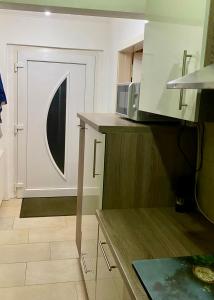 a small kitchen with a microwave and a door at Ferienhaus am Netzener See in Lehnin +8 photos