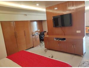 a bedroom with wooden cabinets and a flat screen tv at Royal Park-Hotels & Resorts, Ghaziabad in Ghaziabad