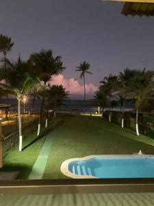 een zwembad naast een strand met palmbomen bij Beira Mar in Salvador