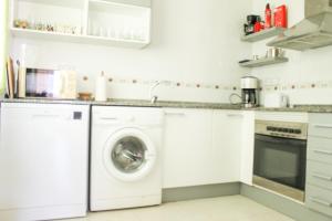 biała kuchnia z pralką i suszarką w obiekcie 3 bedroom duplex apartment san cayetano w mieście San Javier