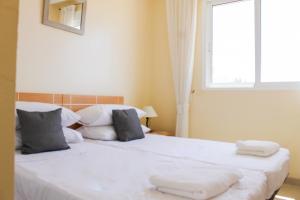 sypialnia z 2 łóżkami z białą pościelą i oknem w obiekcie 3 bedroom duplex apartment san cayetano w mieście San Javier
