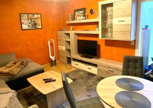 a living room with a couch and a table with a television at Ferienhaus am Netzener See in Lehnin
