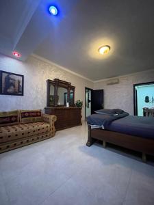 a bedroom with a bed and a couch at Marina Agadir Appartement in Agadir