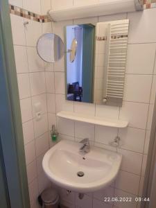 a bathroom with a sink and a mirror at Dom Gościnny Klemens in Dębki